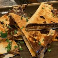 Beefy Brisket Quesadilla · Flour tortilla toasted with  pepper jack cheese, caramelized onions, chopped brisket and tan...