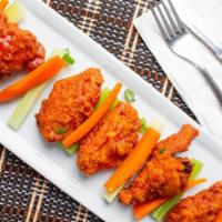 Buffalo Wings · Crunchy chicken wings lathered in buffalo sauce with french fries