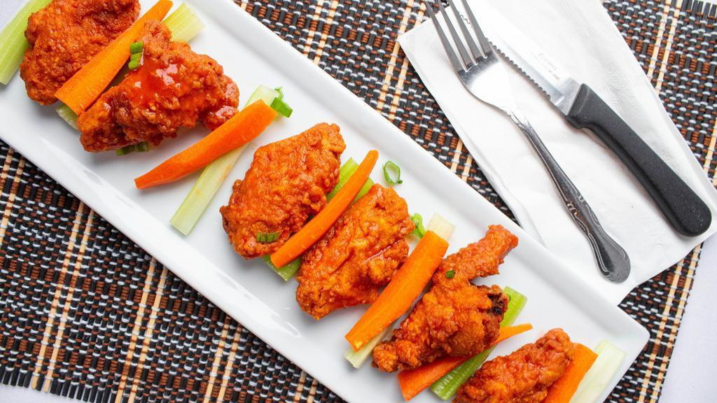 Buffalo Wings · Crunchy chicken wings lathered in buffalo sauce with french fries