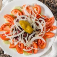 Greek Village Salad · Feta cheese, onions, cucumbers, tomatoes, peppers, Greek olives, and dressing with pita brea...