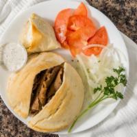 Deluxe Plate · Served with onions, tomatoes, tiropita, and tzatziki sauce.