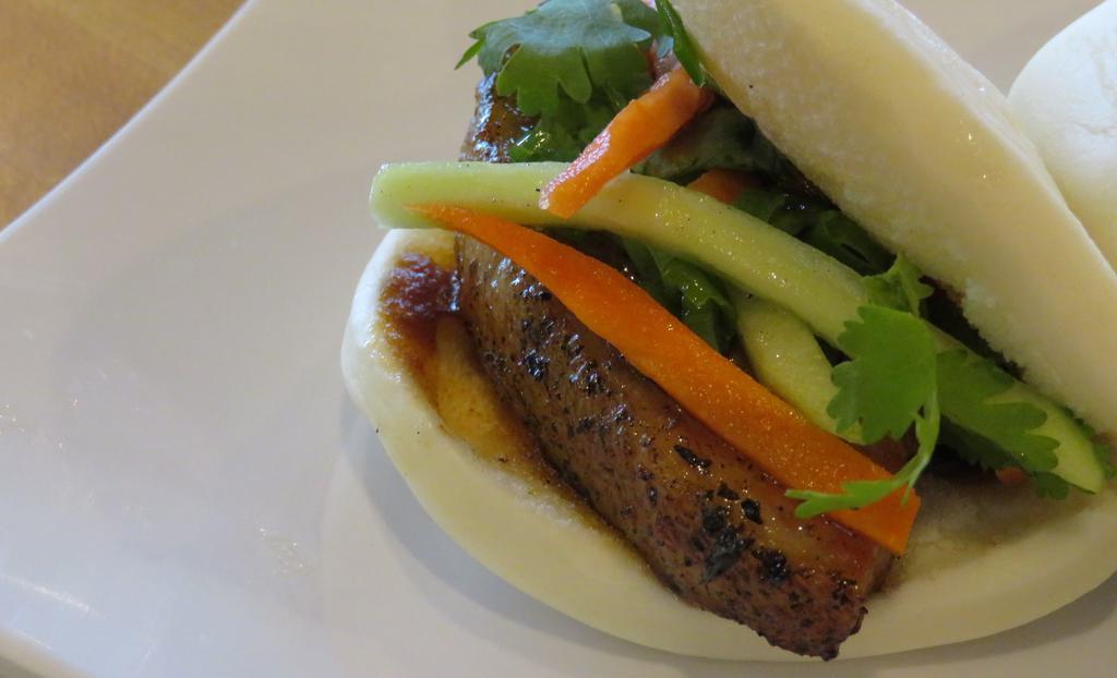 Bao Buns (2 Pc) · In a sweet rice bun, house spicy hoisin, pickled carrots, cilantro, cucumber, green onion.