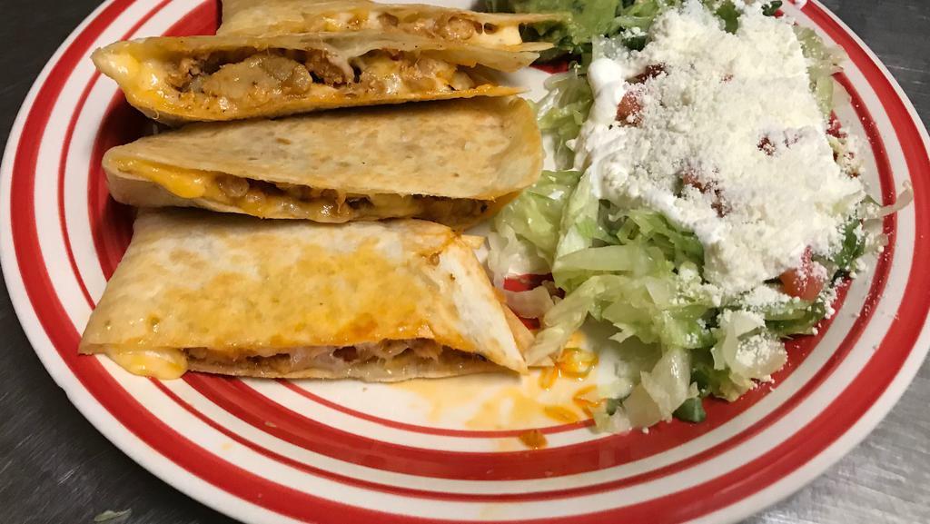 Quesadilla · Inside: meat of choice, flour tortilla filled with mix cheese served with lettuce, dice tomatoes, sour cream covered with powder cheese.