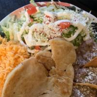 Pollo Asado · Grilled chicken with grilled onions on top and side of rice, beans and salad