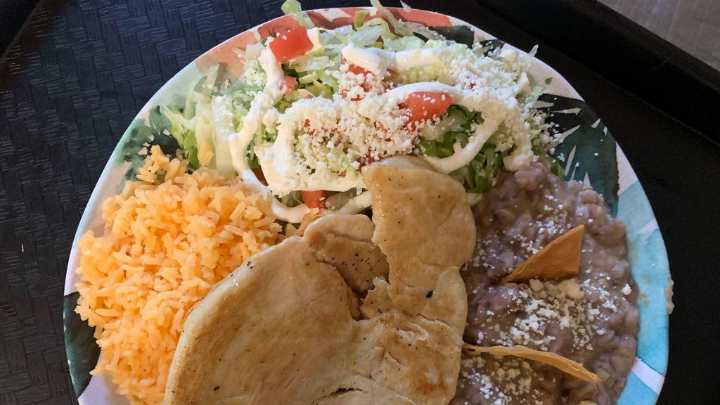 Pollo Asado · Grilled chicken with grilled onions on top and side of rice, beans and salad