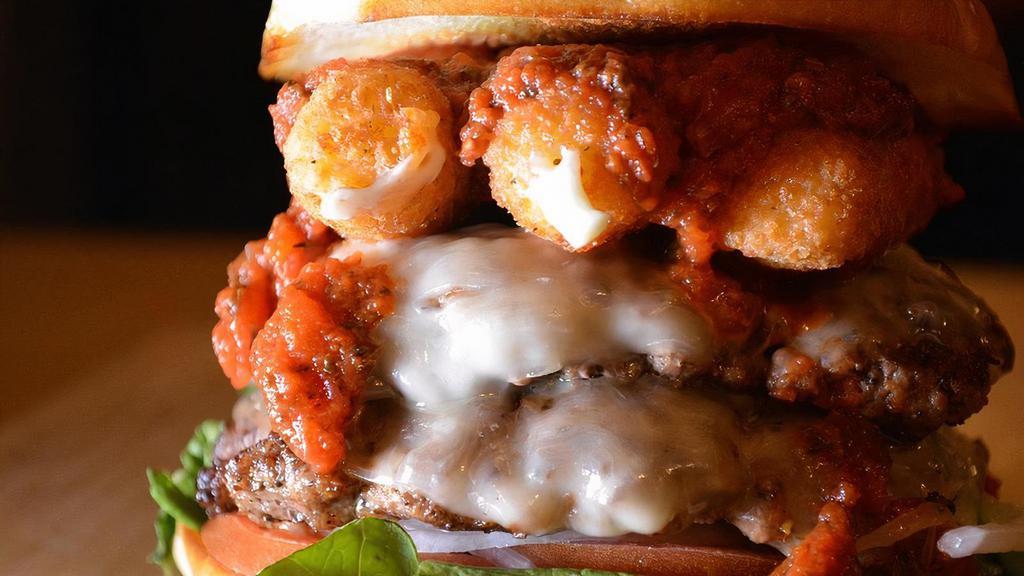 Mozzy Burger · Topped with Provolone cheese, mozzarella sticks, marinara sauce, mixed greens, tomato and onion