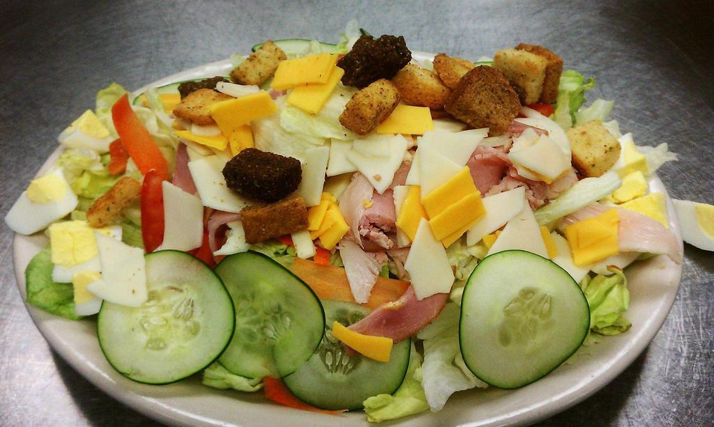 Chef Salad · Ham and turkey with provolone and cheddar cheese, carrots, tomatoes, and cucumbers on a fresh bed of lettuce.