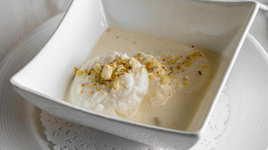 Rasmalai · Two pieces. Homemade cheese in special condensed milk flavored with rose water and garnished with pistachio.