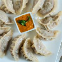 Mo Mo (6) · Steamed dumplings choice of chicken or vegetables, side of tomato.
