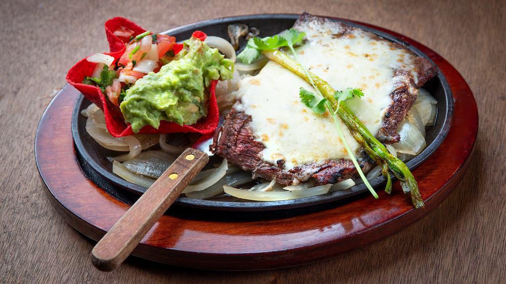 Carne Asada · A 10oz. Choice skirt steak topped with Monterey cheese.
Served with guacamole, pico de gallo, charro beans, rice and
tortillas.