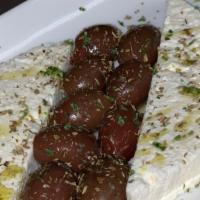 Greek Feta & Olives · Block of feta cheese surrounded by kalamata olives and drizzled with EVOO.