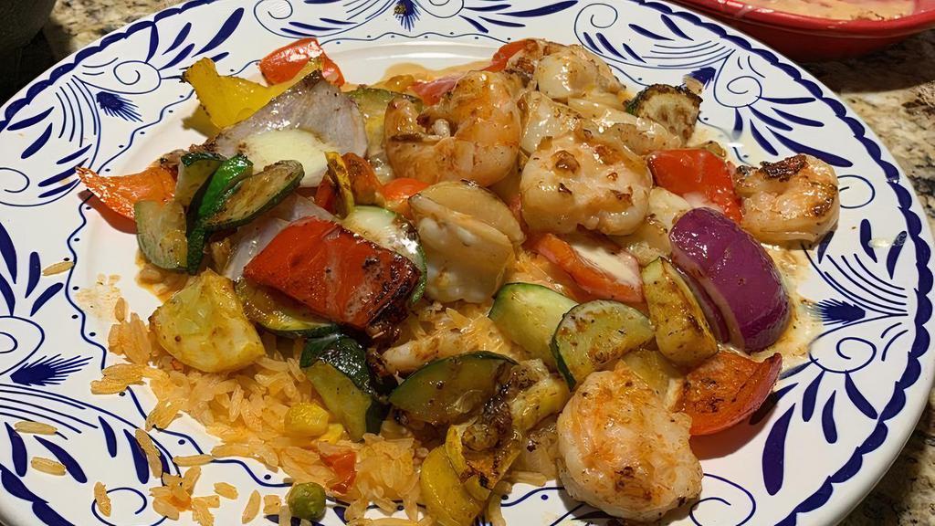 Camarones Locos · Favorite. Grilled shrimp, scallops, bell peppers, onions and zucchini served over rice and our cheese sauce.