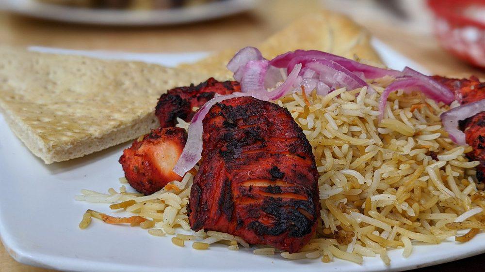 Tandoori Chicken · Leg and a thigh piece marinated in a yogurt and tandoori sauce. Served with Afghan rice, salad, and Afghan naan.