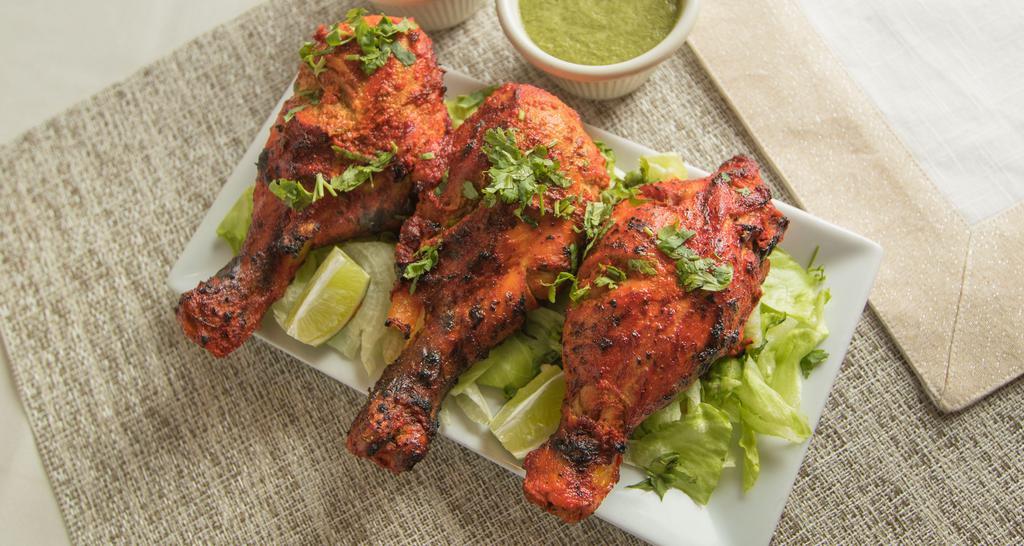 Tandoori Chicken · Chicken leg pieces marinated overnight in yogurt, ginger, garlic and spices and cooked in the tandoor.