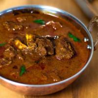 Goat Curry · Goat prepared in a mildly spiced sauce.