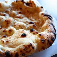 Naan · Soft, fluffy flatbread baked in a tandoor oven.