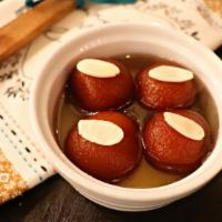 Gulab Jamun Dumplings · Fried Indian milk dumplings drenched in a sweet cardamom and rose syrup. Served warm