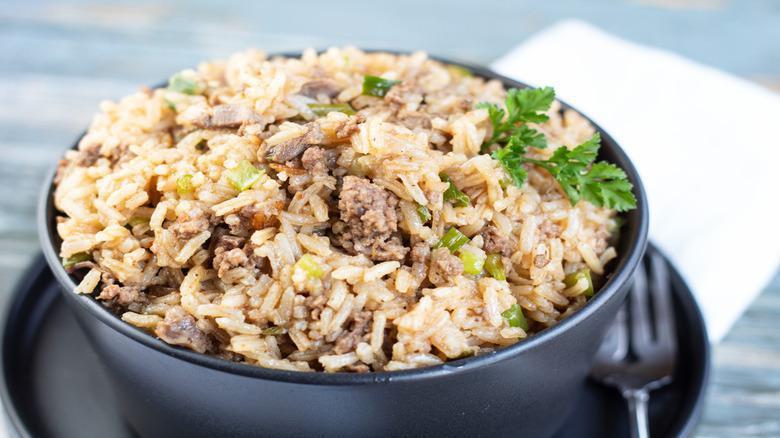 Cajun Fried Rice · Cajun spice-infused fried-rice sautéed with your choice of meats, seafood, and vegetables then drizzled with a Cajun-Asian fusion sauce. Includes broccoli unless specified, also accompanied by an organic greens salad and garlic butter croissant.