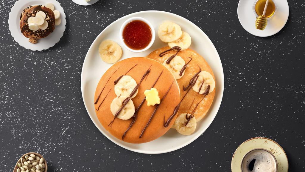 Banana Nutella Pancakes · Fluffy banana nutella pancakes cooked with care and love served with butter and maple syrup. Served in threes.
