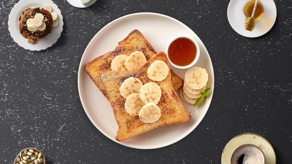 Banana French Toast · Fresh bread battered in egg, milk, and cinnamon cooked until spongy and golden brown. Topped with powdered sugar, sliced bananas, and served maple syrup.