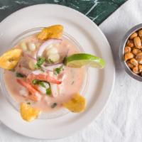 Leche De Tigre · Tiger's milk, concentrated Peruvian ceviche, marinated with generous chunks of fish and topp...