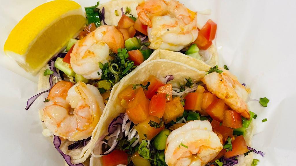 Shrimp Tacos · order of 2. Sautéed in lemon butter and house seasoning cabbage, cucumber, tomato, with cilantro lime aioli sauce.