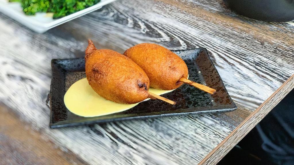 Thai Corn Dogs · house-made Thai sausage: ground pork, lemongrass and red curry, battered to order, served with honey mustard sauce. **mild spiciness**
