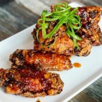 Saucy Wings · crispy chicken wings, soy ginger honey glaze, green onions.