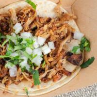 Carnitas Taco · Pulled pork on corn tortillas + white onions and cilantro, just pick your salsa spice level.