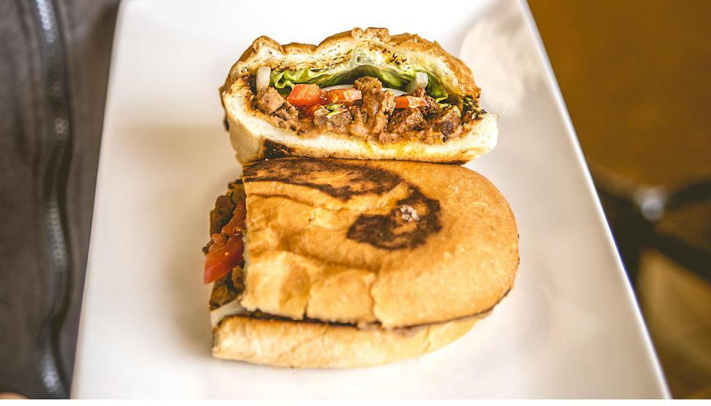 Al Pastor Torta · Marinated pork. Mexican sandwich that includes refried beans, onions, guacamole, lettuce, tomatoes, and mayonnaise.