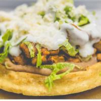 Carnitas Sope · Pulled pork. A handmade tortilla fried and topped with beans, lettuce, queso fresco, and cre...