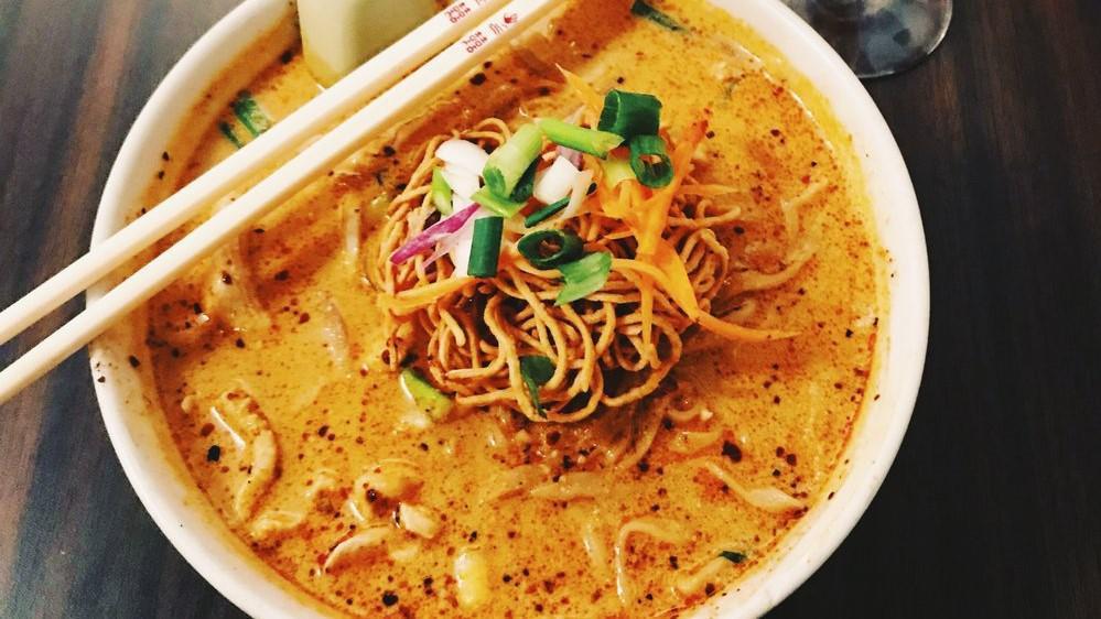 Khao Soi · Popular northern thai dish made with egg noodle and choice of meat in yellow curry-like soup, topped with crunchy egg noodle, green onion, and cilantro, served with pickled mustard and bean sprout. Spicy.