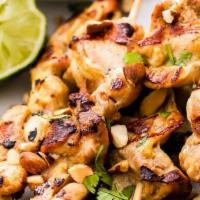 Chicken Satay (2) · Marinated chicken on skewers, served with herbs, picked vegetables, and peanut sauce