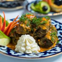 Dolma · Ground beef and rice, seasoned to perfection and wrapped in grape leaves, served with sour c...