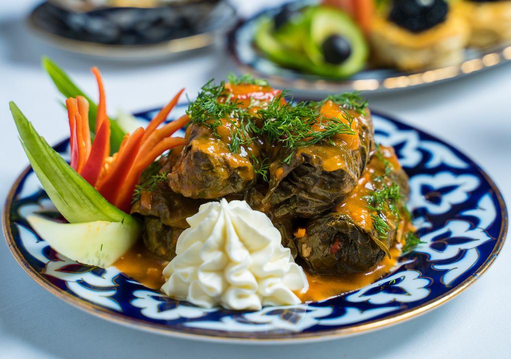 Dolma · Ground beef and rice, seasoned to perfection and wrapped in grape leaves, served with sour cream, and a tomato based sauce.
