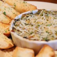 Creamy Artichoke & Spinach Dip · Baby spinach and rich artichokes with cream cheese, asiago and a pinch of nutmeg, served wit...