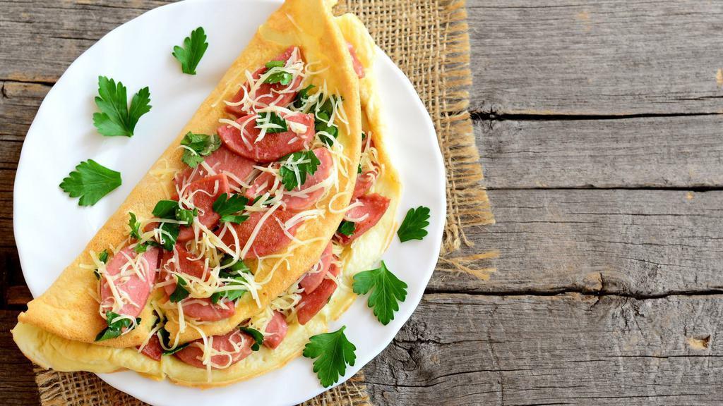 Ham & Cheese Omelette · Fresh ham slices with cheese wrapped in omelette and served with beans, potatoes, and two tortillas.