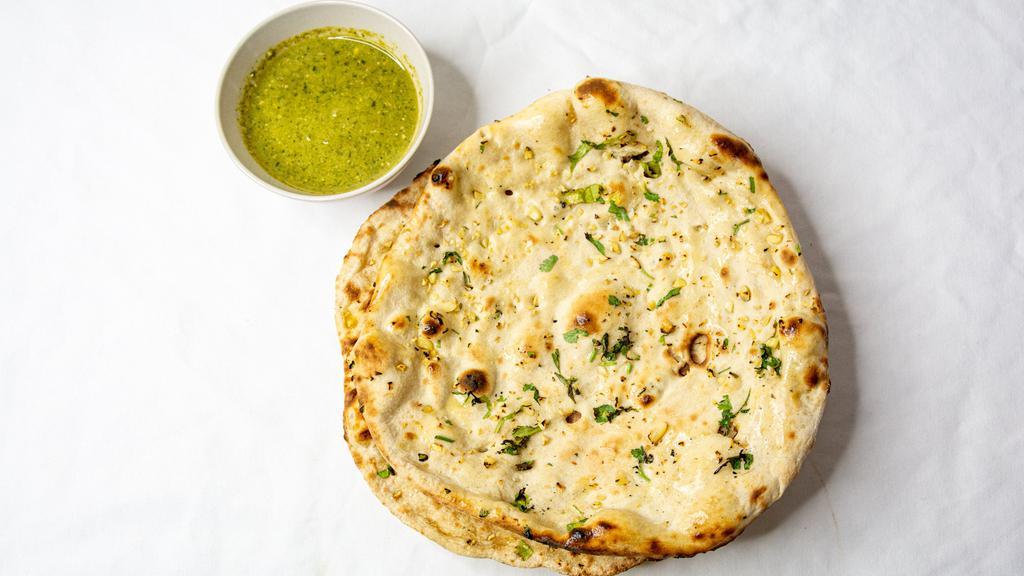 Garlic Naan · Tandoor baked flat bread topped with garlic and butter.