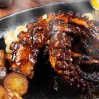 Pulpo Anticuchero · Charcoal grilled octopus served with grinded rustic potatoes, corn & 