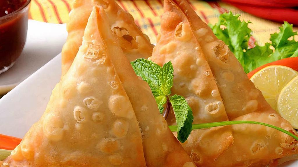 Vegetable Samosas (2) · Triangle pastries with potatoes, peas and spices.