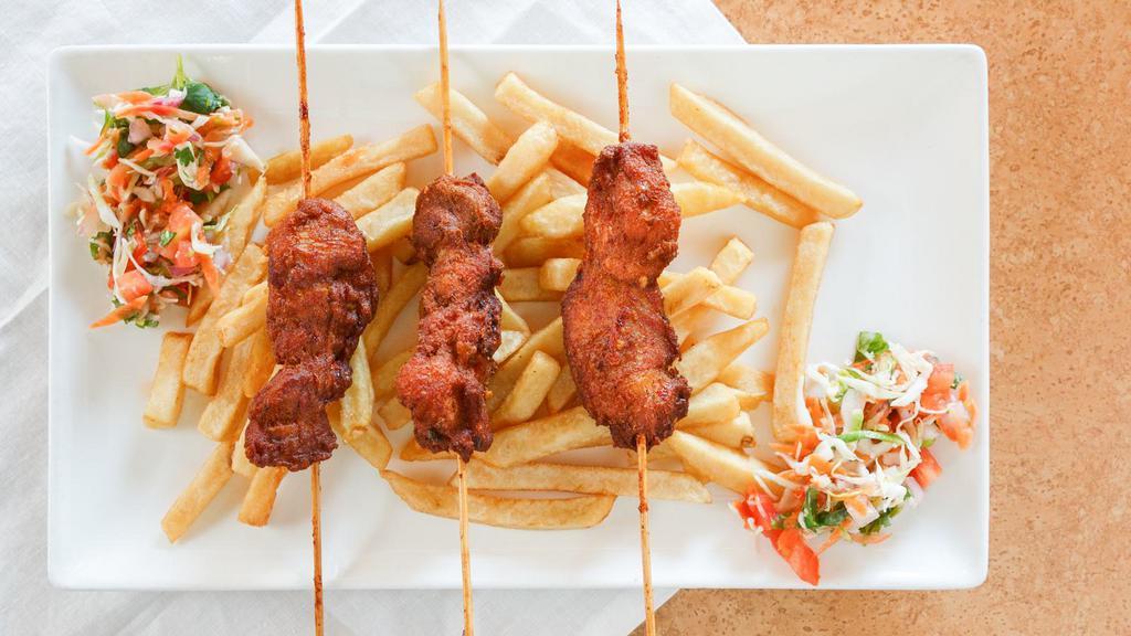 Chicken Skewers And Plantains Or Fries With Sauce · Three chicken skewers marinated in assorted herbs and spices and fried to perfection. Served with plantains, sauce and kachumbari salad garnish