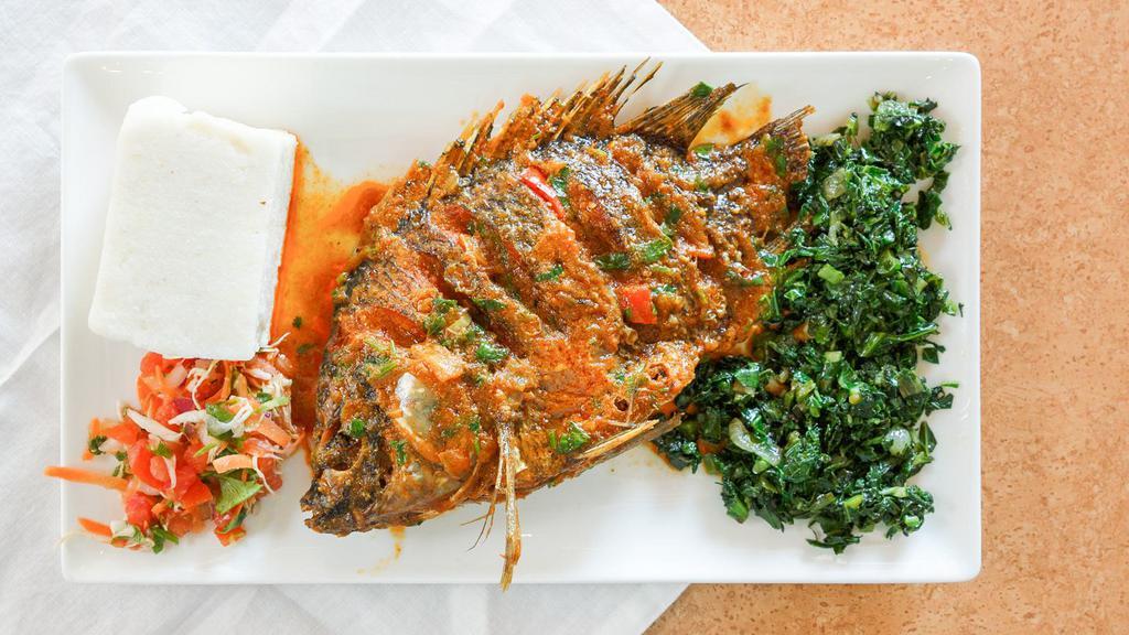 Fish In Sauce · Whole bone in tilapia fish marinated in assorted spices and deep fried to perfection then cooked in a delicious house sauce with fresh ginger, garlic, onions, peppers and fresh herbs.