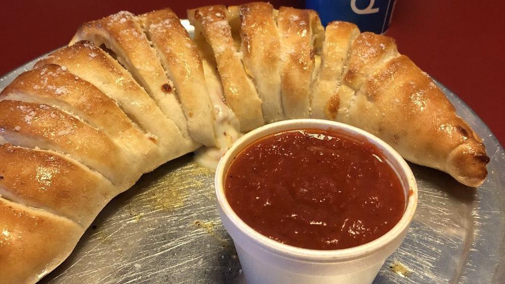 Calzone W/ One Item · Homemade dough stuffed with topping of choice, and mozzarella cheese, folded over and baked to perfection. Topped with marinara sauce and cheese. 
Extra toppings are available for an additional charge.