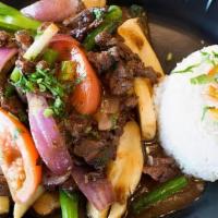 Lomo Saltado · Peruvian stir fry combining marinated beef, red onions, spring onions, tomatoes, and cilantr...