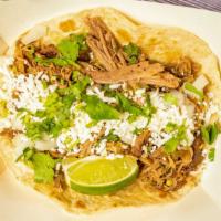 16 Carnita · TENDER BRAISED SPICED PORK TOPPED WITH QUESO FRESCO, FRESH ONION, AND CILANTRO WITH A SLICE ...