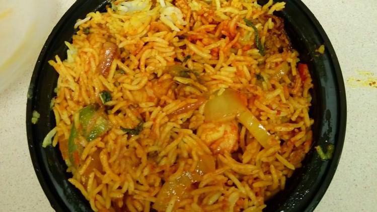 Chicken Biryani · Basmati rice flavored with spices and saffron, cooked with marinated chicken pieces to an aromatic and savory combination.