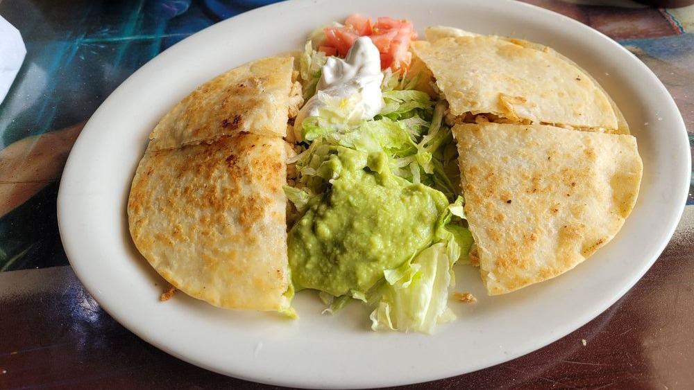 Fajita Quesadilla · A super flour tortilla stuffed with grilled chicken or juicy steak and shredded cheese. Garnished with lettuce, tomatoes, sour cream and guacamole.