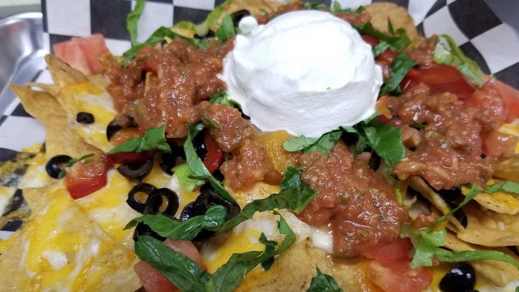 Nachos · A mound of fresh fried corn tortilla chips topped with cheddar jack cheese, diced tomatoes, black olives, shredded lettuce, cherry peppers, sour cream and freshhouse made salsa