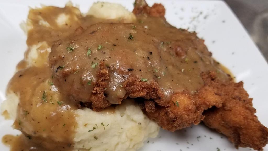 Country Fried Chicken · Buttermilk chicken breast lightly breaded and deep fried to a golden brown over garlic mashed potatoes and smothered in a light gravy