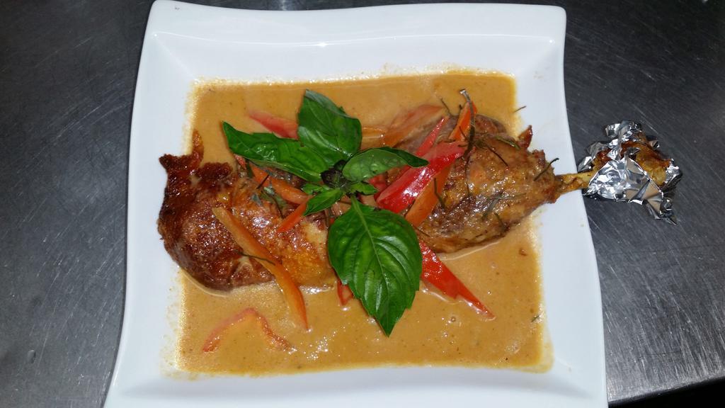Panang Ped · Spicy. Crispy duck with panang curry coconut milk, red peppers, and lime leaves.